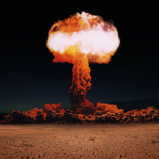 Nuclear explosion with a large mushroom cloud in a desert landscape